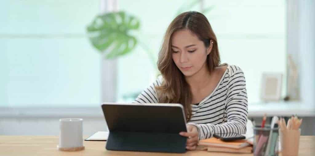 woman using a tablet to create a budget using one of the best budgeting methods in this list