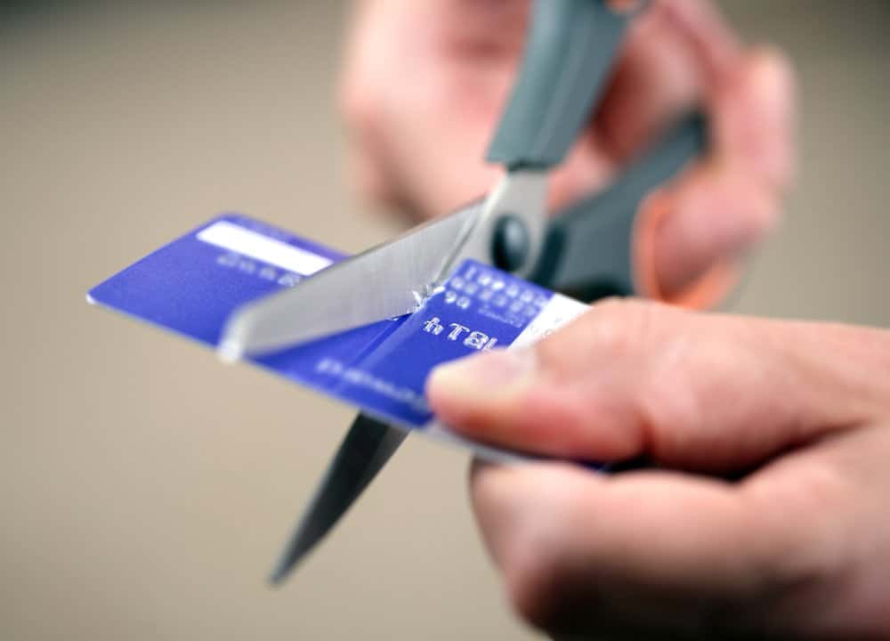 someone cutting up credit card to live cheap
