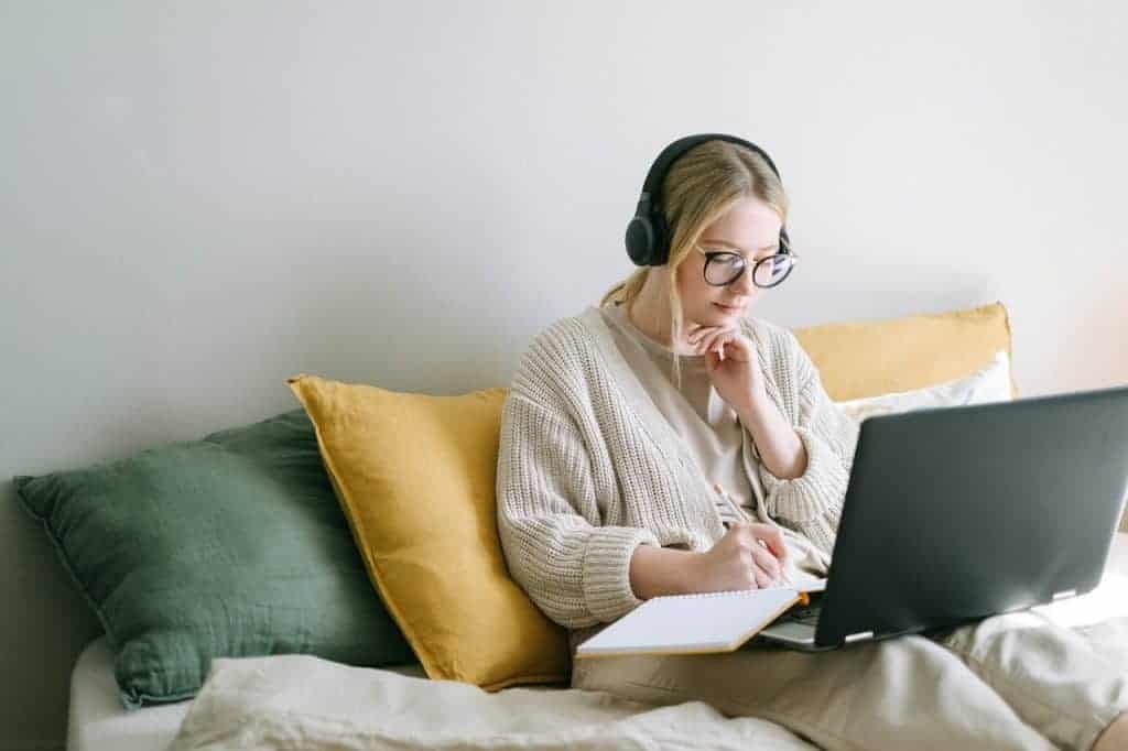 woman on laptop with headphones getting paid for typing for money