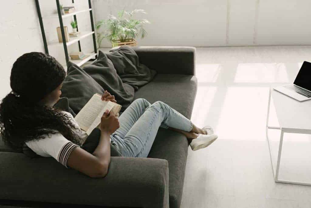 woman reading financial planning quotes on a sofa