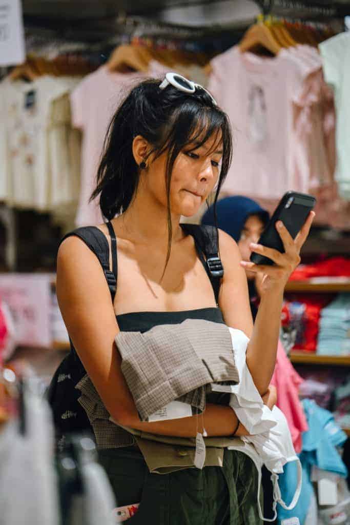 woman using ibotta app while shopping