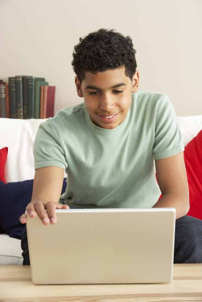boy using laptop to find online jobs for 16 year olds at home