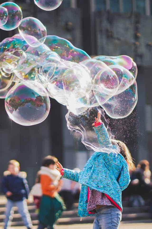 child playing with bubbles