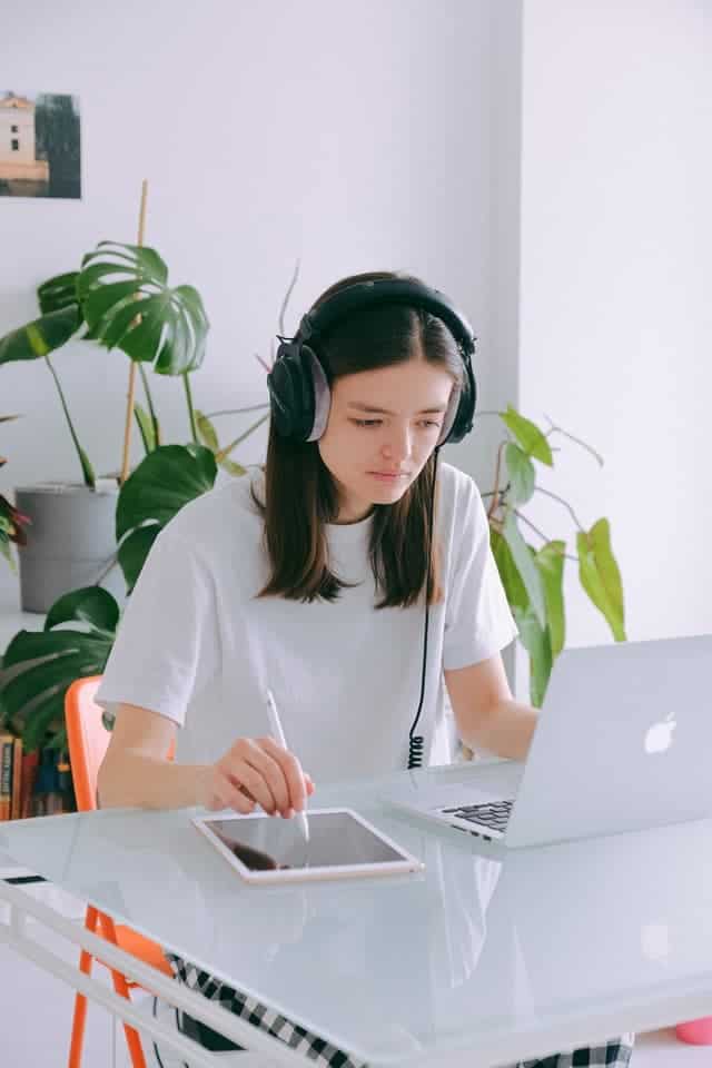 woman working on laptop listening to headphones