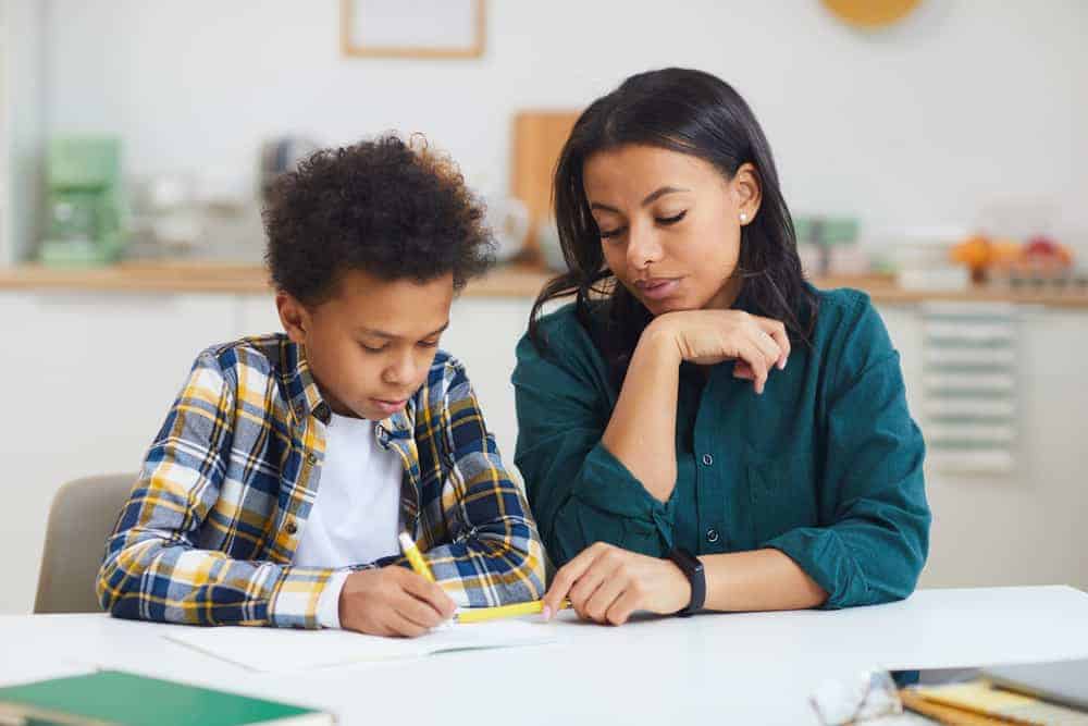 woman teaching boy wondering how much should I charge for tutoring