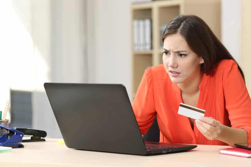 woman with laptop wondering why her debit card declined when she has money