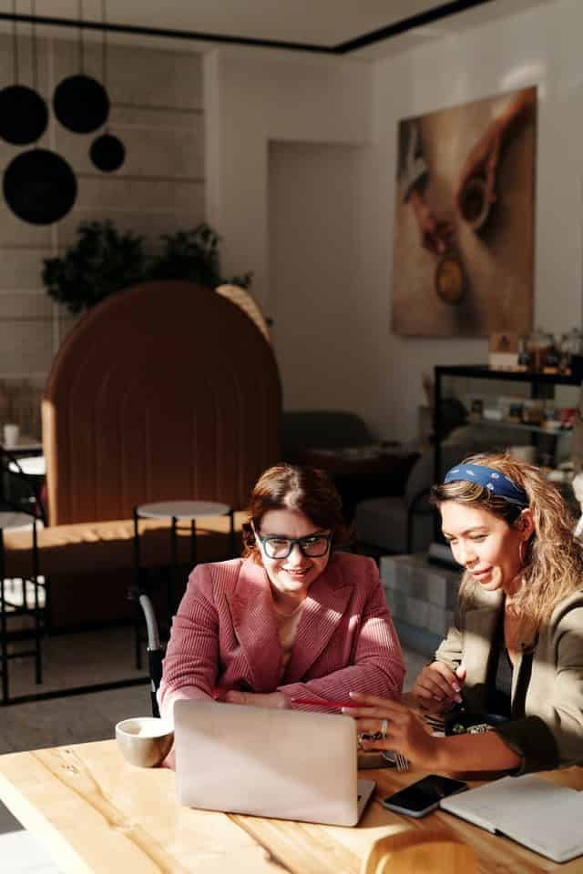 two women at cafe with a laptop