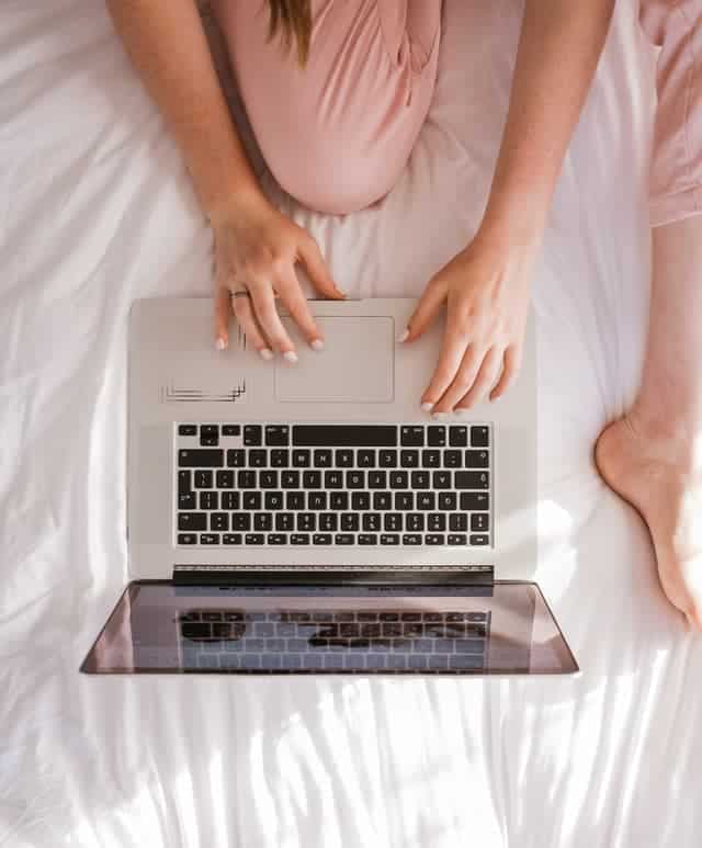 woman working on laptop to sell feet pics online