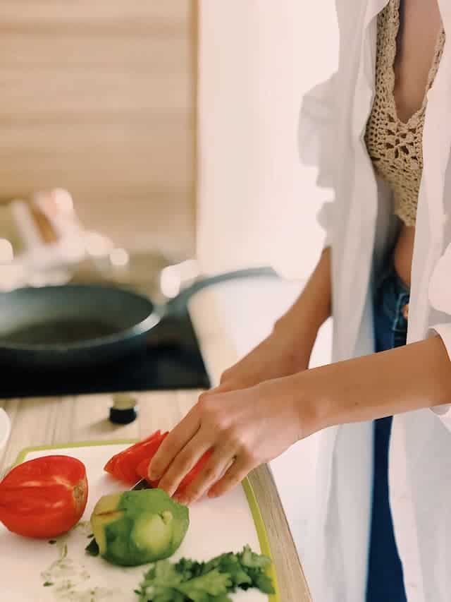 woman cooking as part of her 30 day habit challenge for clean eating