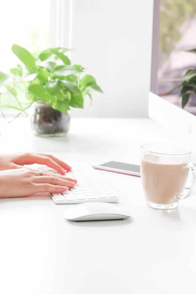 person on computer with coffee