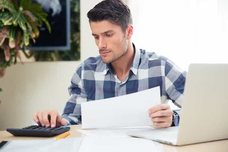 man looking at documents to calculate $15 an hour is how much a year