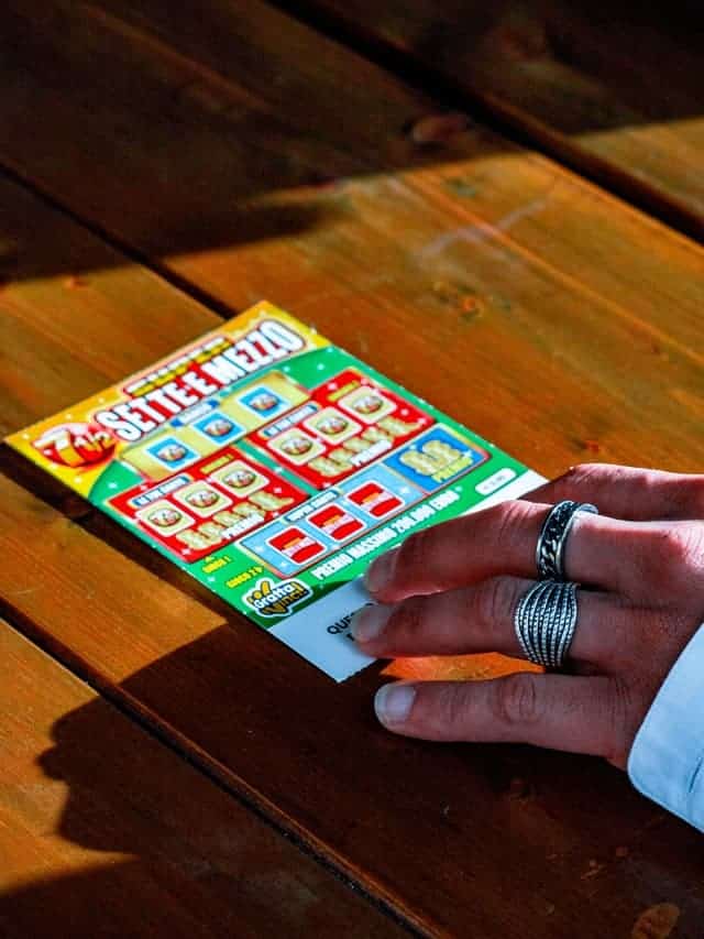 person holding a scratch ticket wondering if their right hand is itching for lottery luck