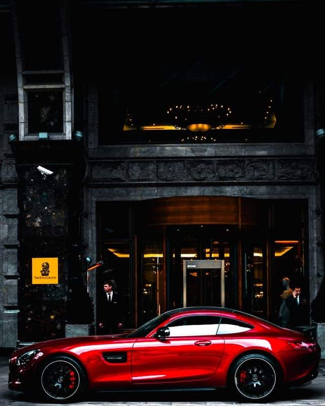 sports car in front of hotel showing the old money vs new money style