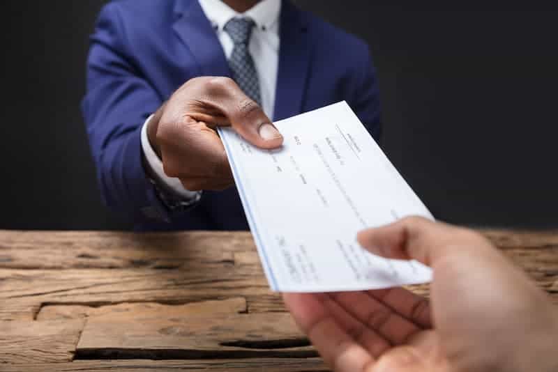 man handing over a certified check