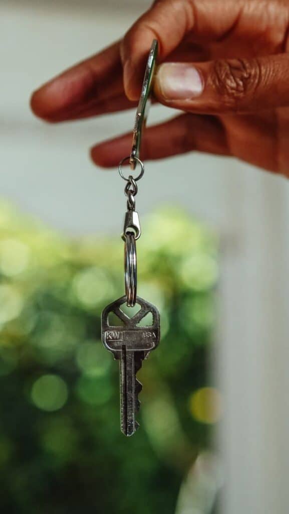 person holding key to new place after having covered their costs of renting