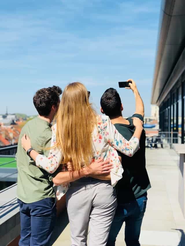 group of friends taking a selfie to upload their photos and get paid