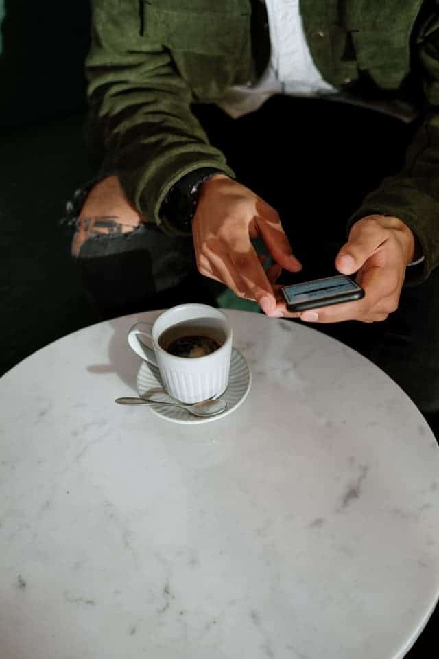 person using phone at a cafe to get the best Swagbucks offers