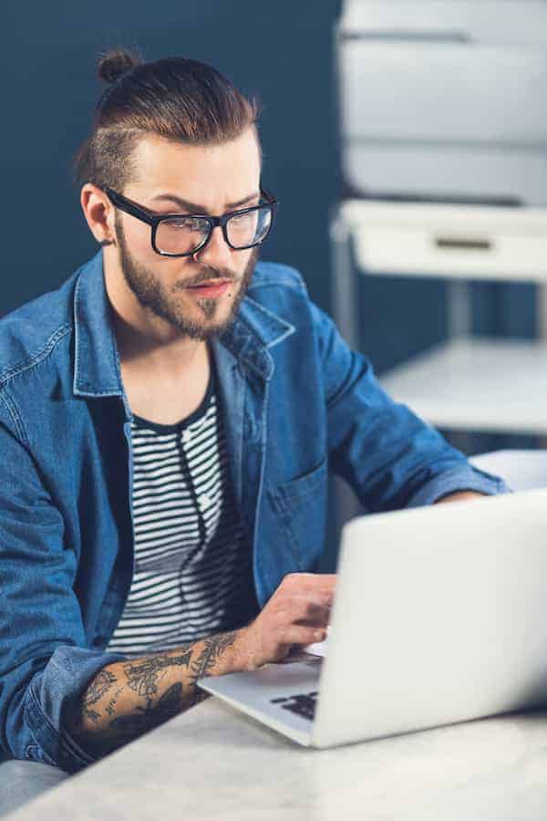 man on laptop looking for the best way to sell baseball cards online