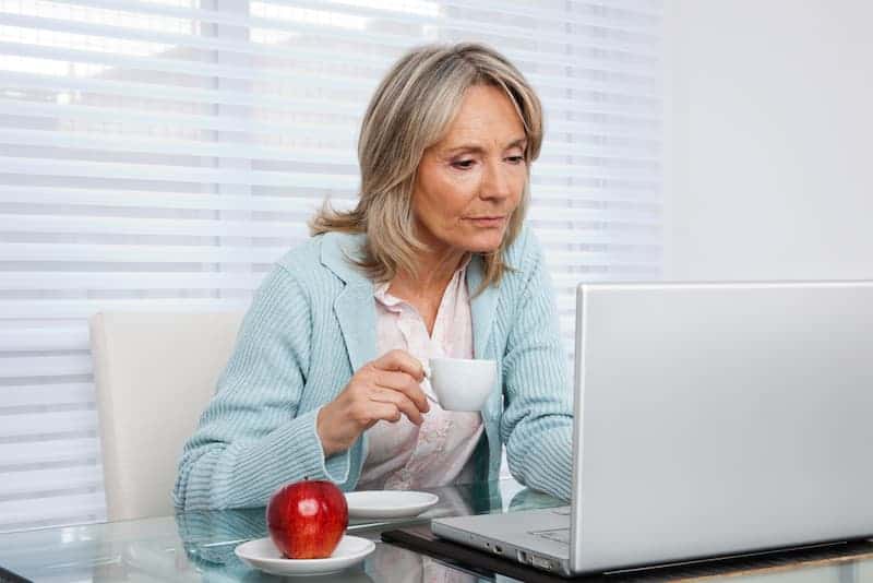 woman on laptop working at a low stress job after retirement