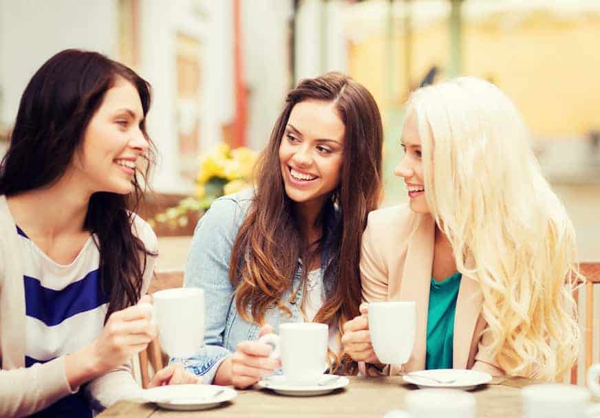 three women drinking coffee together