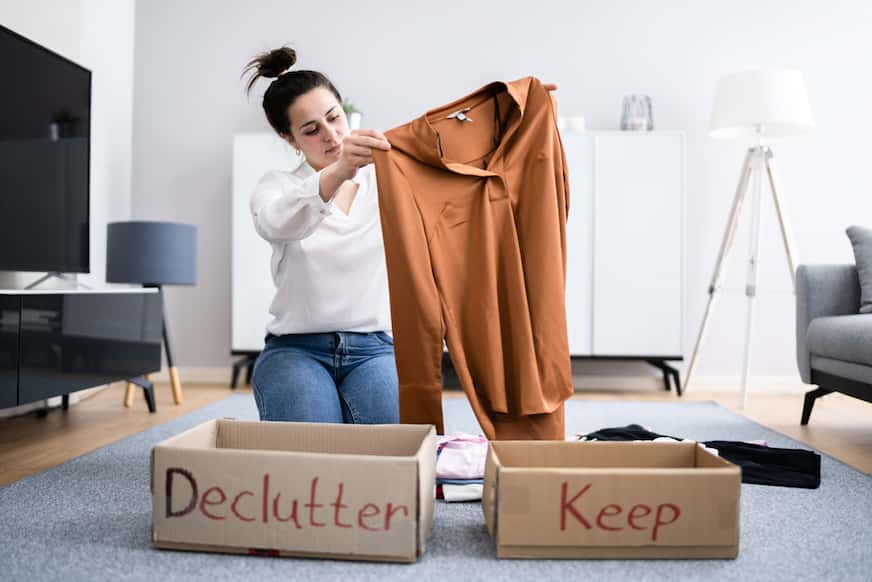 woman decluttering clothes by packing them in boxes to make $2000 free money
