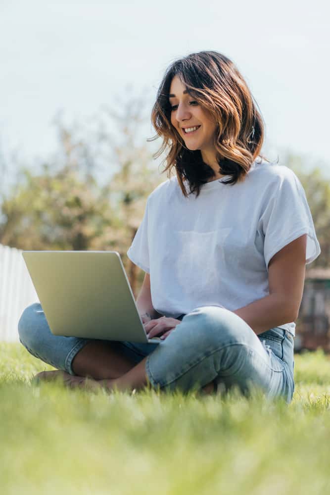 woman on her laptop outside working at selling stickers online