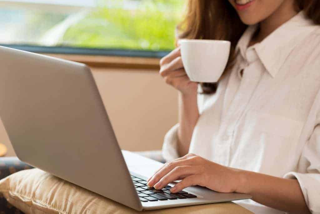 a woman drinking her coffee at home instead of ordering to save $1000 a month