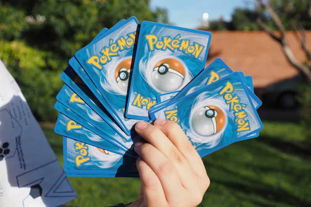 A man holding pokemon cards to sell