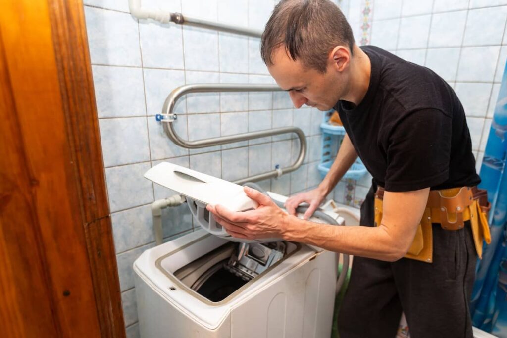 a man doing a repair on a washing machine