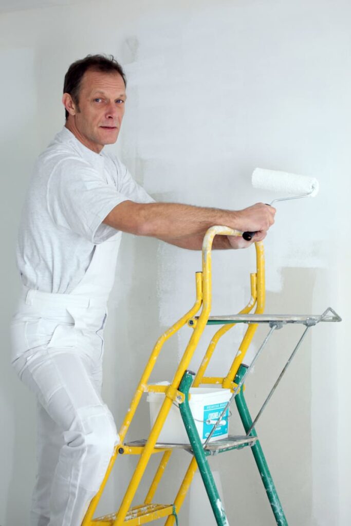 a man painting a wall working as an interior decorator a low stress job after retirement