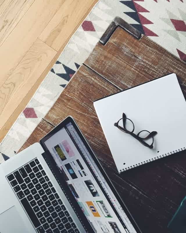 a laptop, notebook, and eyeglasses