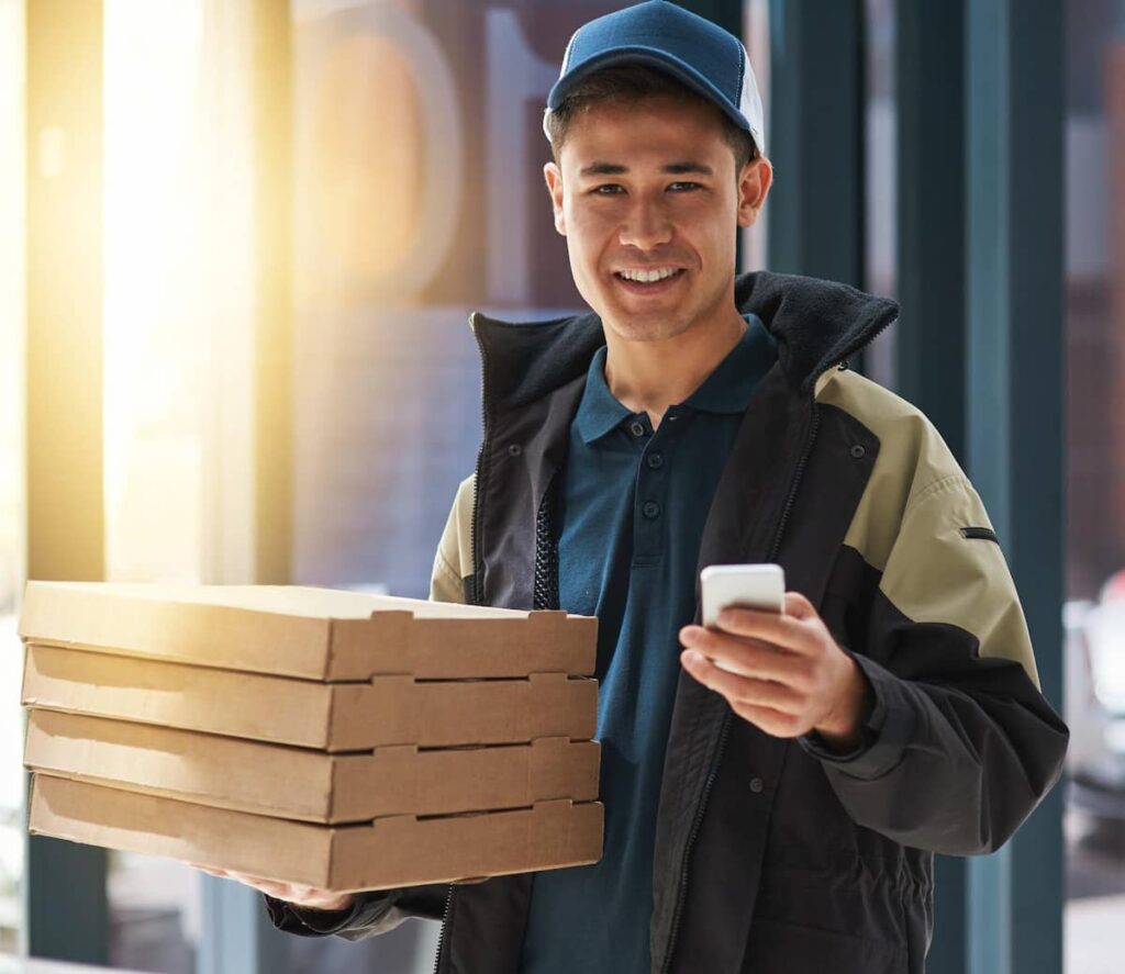 a delivery man holding boxes of pizza