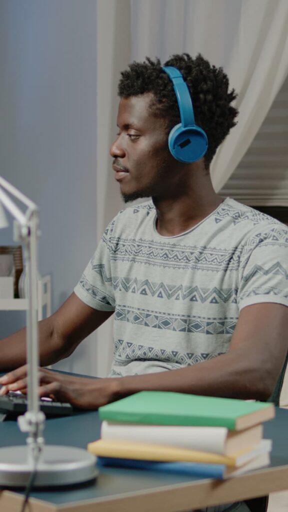 a man typing with a headphone