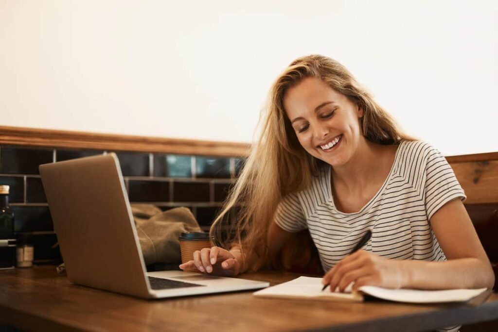 a woman in front of her laptop and writing some lifestyle blog post ideas