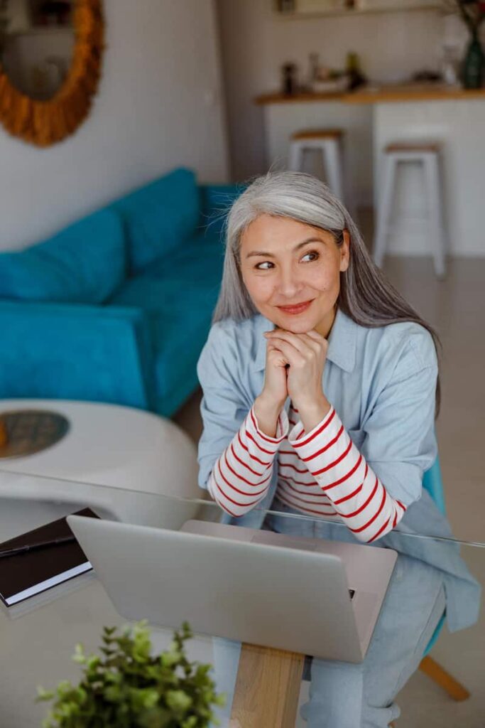 a woman with her laptop thinking about lifestyle blog post ideas