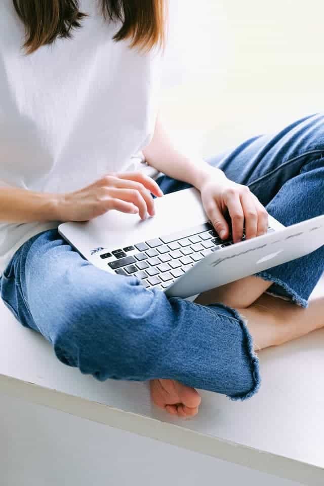 a woman with laptop working as a chat moderator a great side hustle for nurses