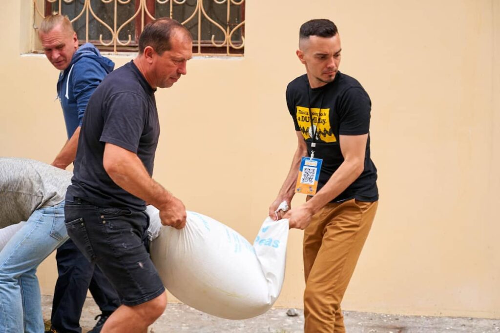 two humanitarian aid worker holding a sack of rice