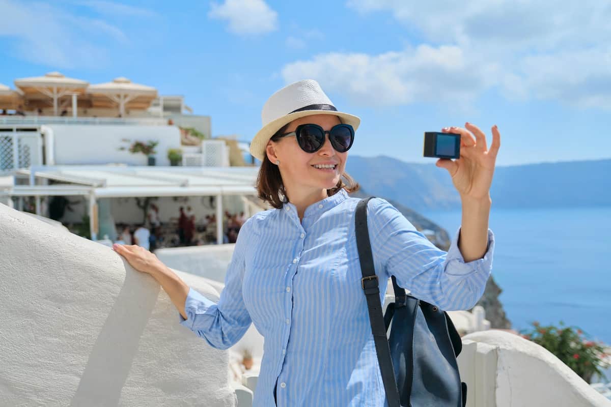 a woman holding a camera earning money with travel jobs
