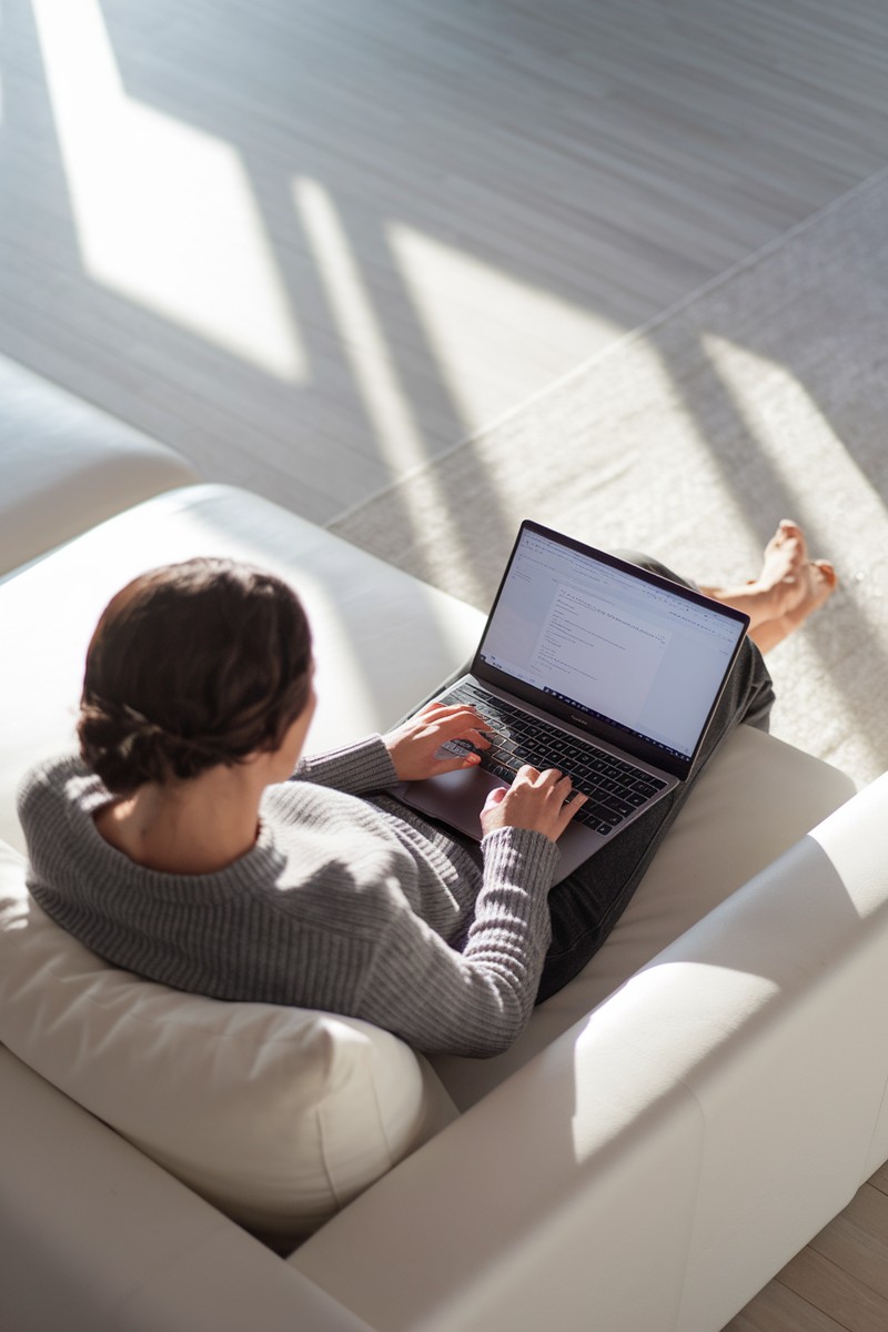 woman using a laptop in a bright living room