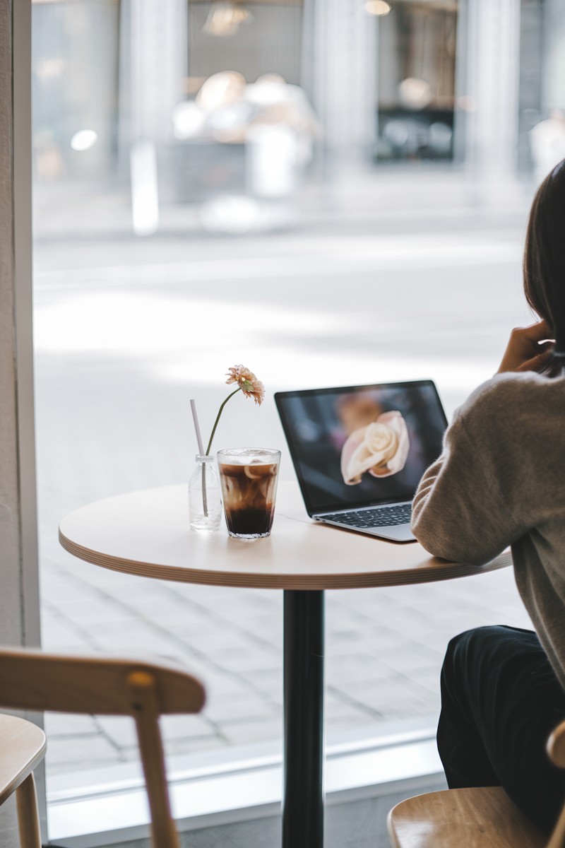woman working on her laptop at a bright cafe