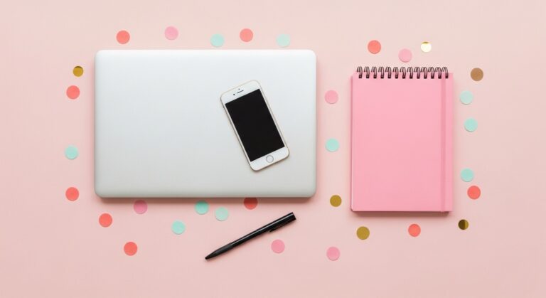 pink flatlay with laptop, notebook, and phone