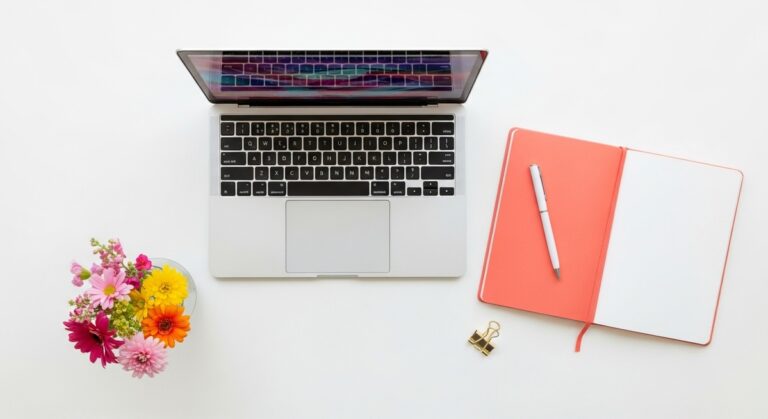 flatlay with laptop and other items on a white surface
