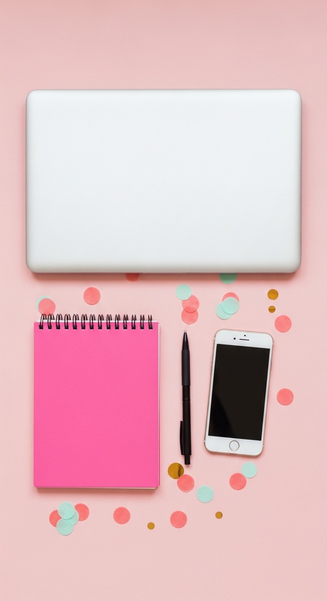 a pink flatlay with laptop, notebook, and phone for typing jobs