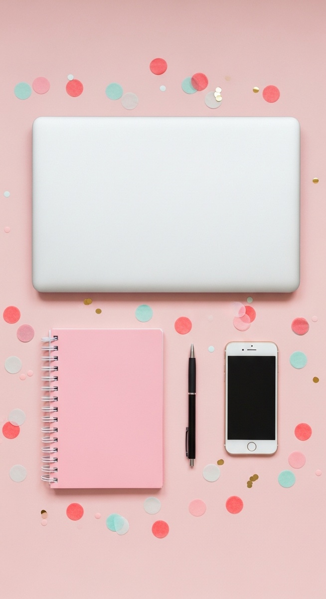 pink flatlay with laptop, notebook, and phone