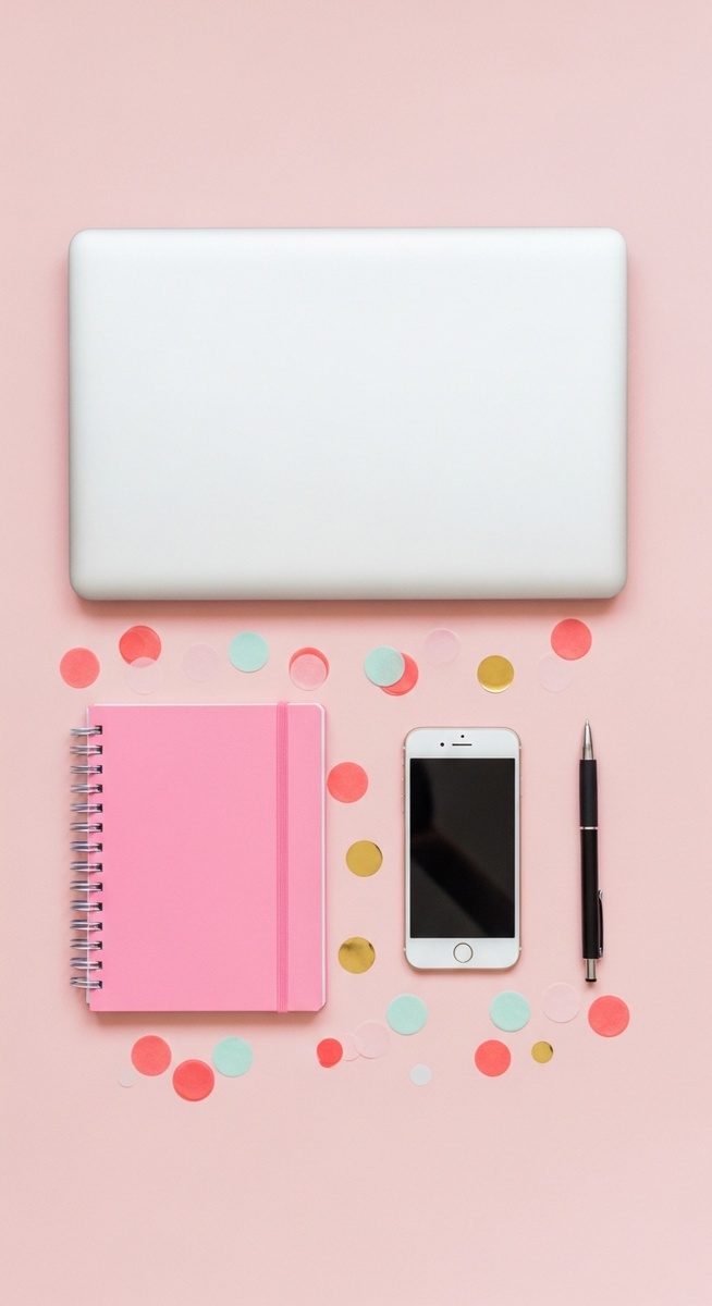 pink flatlay with laptop, notebook, and phone