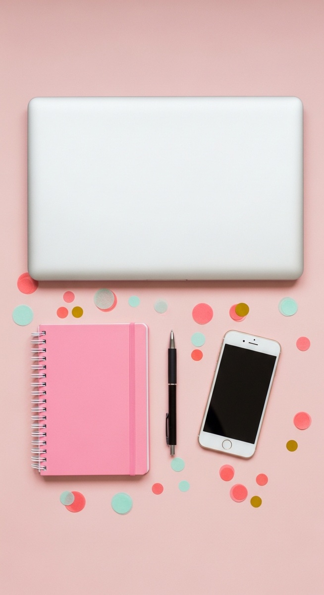 pink flatlay with laptop, notebook, and phone