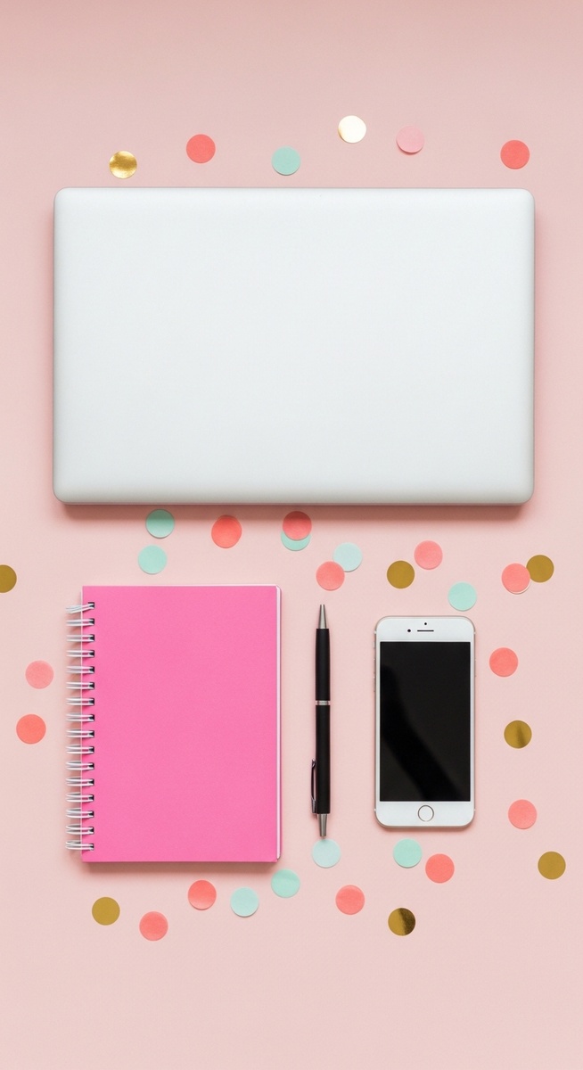 pink flatlay with laptop, notebook, and phone