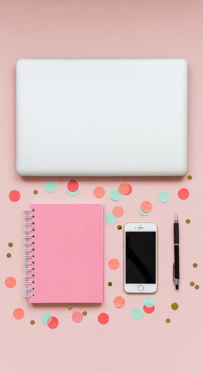 pink flatlay with laptop, notebook, and phone
