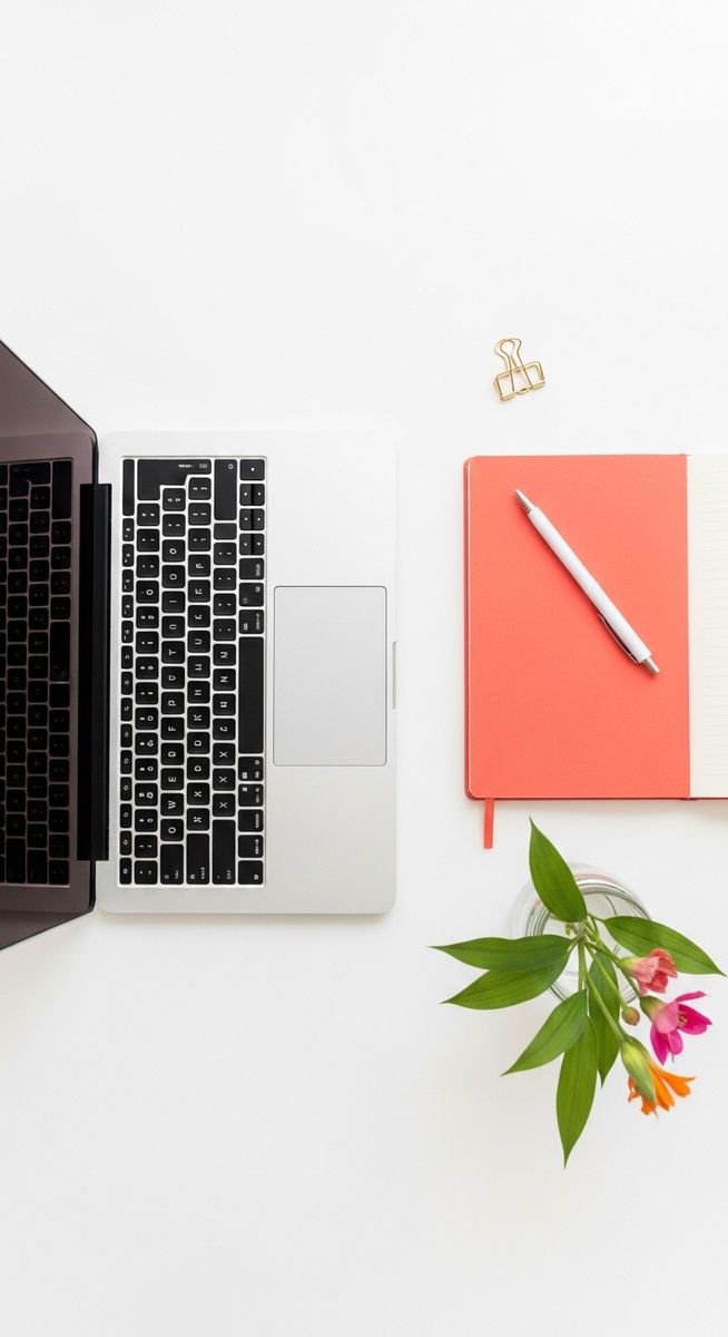 flatlay with laptop and other items on a white surface