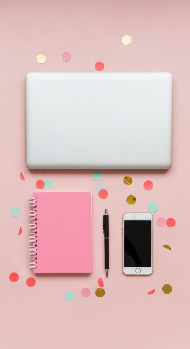 pink flatlay with laptop, notebook, and phone